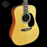 Acoustic guitar with a visible brand logo on a black background