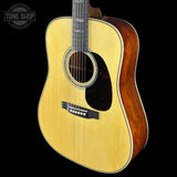 Acoustic guitar with a visible brand logo on a black background