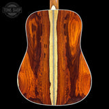 Close-up of a wooden acoustic guitar back with 'Tone Shop' logo.