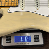 Guitar being weighed on a digital scale with a display showing weight.