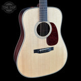 Acoustic guitar with a visible brand logo on a black background