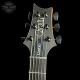 Guitar headstock with 'Custom' branding on a black background