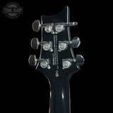 Close-up of the headstock of aPRS electric guitar against a solid black background, showing the six tuning pegs and printed specifications.