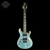 Blue electric guitar on a black background with 'Tone Shop' logo.