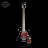 A black electric guitar with a red glitter pickguard, shown against a solid black background. A Tone Shop watermark is visible in the top-left corner.