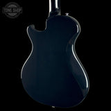 The glossy dark blue back of an electric guitar, photographed against a solid black background with a Tone Shop watermark in the upper left corner.