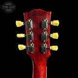 Close-up of a red guitar headstock with tuning pegs on a black background, featuring 'Tone Shop' branding.