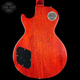 Back view of a red electric guitar with a Gibson logo on a black background
