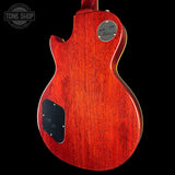 Red electric guitar with a visible brand logo on a black background
