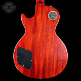 Back view of a red electric guitar with a visible brand logo on a black background