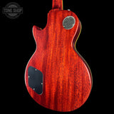 Red electric guitar with a visible brand logo on a black background