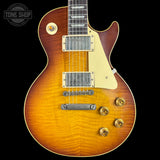 Electric guitar with a sunburst finish on a black background, featuring the Tone Shop logo.
