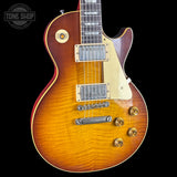 Gibson Les Paul guitar with a sunburst finish on a black background, featuring the Tone Shop logo.