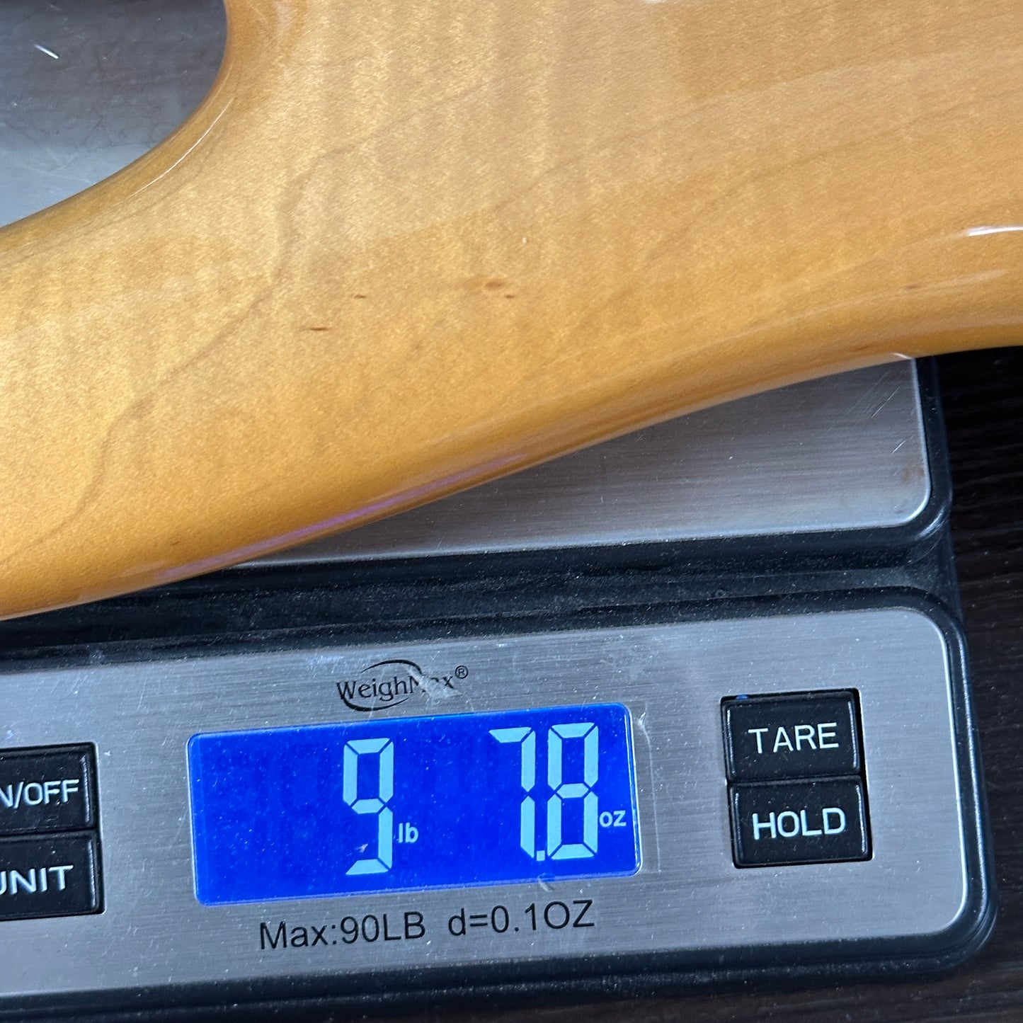 Wooden object on a digital scale displaying weight