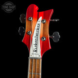Close-up of a red and white bass guitar headstock with 'Rickenkunker' branding on a black background.