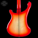 Close-up of a red and orange electric guitar body with 'Tone Shop' logo.