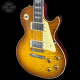 Electric guitar with a sunburst finish on a black background, featuring the Tone Shop logo.