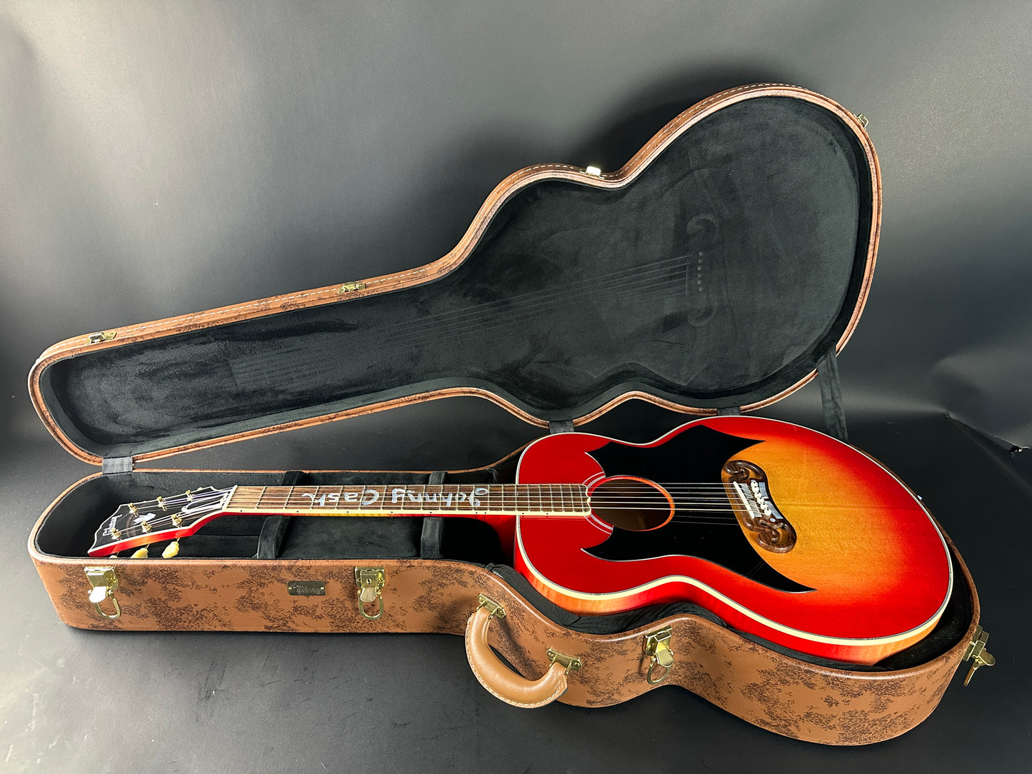 Red acoustic guitar in a case on a gray background