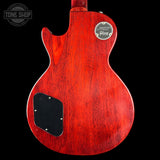 Red electric guitar body with a visible brand logo on a black background