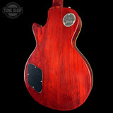 Red electric guitar with Gibson logo on a black background