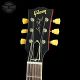 Gibson Les Paul guitar headstock with yellow tuning pegs on a black background