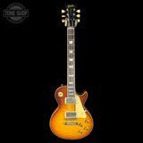 Electric guitar with a sunburst finish on a black background, featuring the Gibson logo.