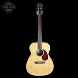 A natural wood acoustic guitar with a dark fretboard and a red glittery pickguard, shown against a solid black background with a Tone Shop logo in the top-left corner.