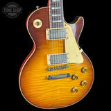 Gibson Les Paul electric guitar with a sunburst finish on a black background, featuring the Tone Shop logo.