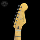 Close-up of a Fender Stratocaster electric guitar headstock in a natural maple finish, showing six silver tuning pegs and the Fender logo, set against a solid black background.