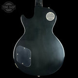 Black electric guitar body with a visible brand logo on a black background