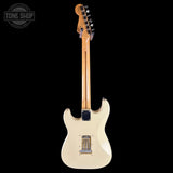 A cream-colored electric guitar shown from the back, featuring a natural wood neck and headstock, set against a solid black background with a Tone Shop watermark in the top left corner.