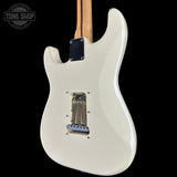 The back of an electric guitar with a glossy off-white body, a natural wood neck, and a black pickguard, shown against a solid black background.