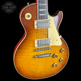 Electric guitar with a sunburst finish on a black background, featuring the Tone Shop logo.