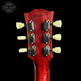 Close-up of a red guitar headstock with tuning pegs on a black background, featuring 'Tone Shop' branding.