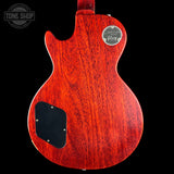 Back view of a red electric guitar with a visible brand logo on a black background.