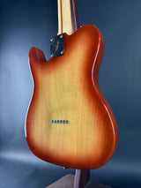 Close-up of a brown electric guitar on a blue background