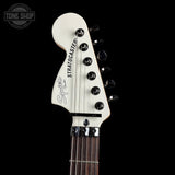 Close-up of a guitar headstock with 'Stratocaster' branding on a black background.
