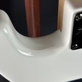 Close-up of a guitar's white neck and wooden fingerboard