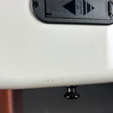 Close-up of a white electronic device with a black battery compartment on a gray background