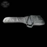 A gray padded guitar or bass gig bag with a zippered front pocket and shoulder strap, shown against a solid black background. A circular Tone Shop logo is visible in the top-left corner.