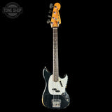 A Fender Jazz Bass electric guitar with a black body, white pickguard, and natural wood headstock, shown against a solid black background with a Tone Shop watermark in the top left corner.