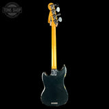 The back view of a vintage Fender Jazz Bass electric guitar with a black body and a natural maple neck, shown against a solid black background with a Tone Shop watermark in the top left corner.