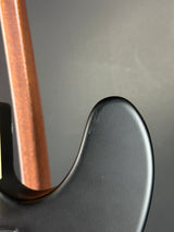 Close-up of a guitar's headstock and tuning pegs with a blurred background