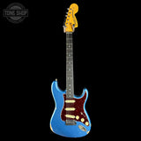 A blue Fender Stratocaster electric guitar with a dark red pickguard and gold hardware, shown against a solid black background. A 'TONE SHOP' watermark is visible in the top-left corner.