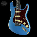 A blue electric guitar with a distressed finish, featuring a dark red tortoiseshell pickguard, cream humbucker pickups, and a chrome headstock cover, shown against a black background.