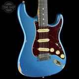 A blue Fender Stratocaster electric guitar with a distressed finish, featuring a dark red pickguard and gold hardware, shown against a black background with a Tone Shop watermark.