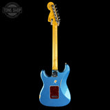 A blue electric guitar with a yellow maple neck and headstock, shown from the back against a solid black background. A Tone Shop watermark is visible in the top-left corner.