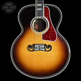 Acoustic guitar with a sunburst finish on a black background, featuring the Tone Shop logo.