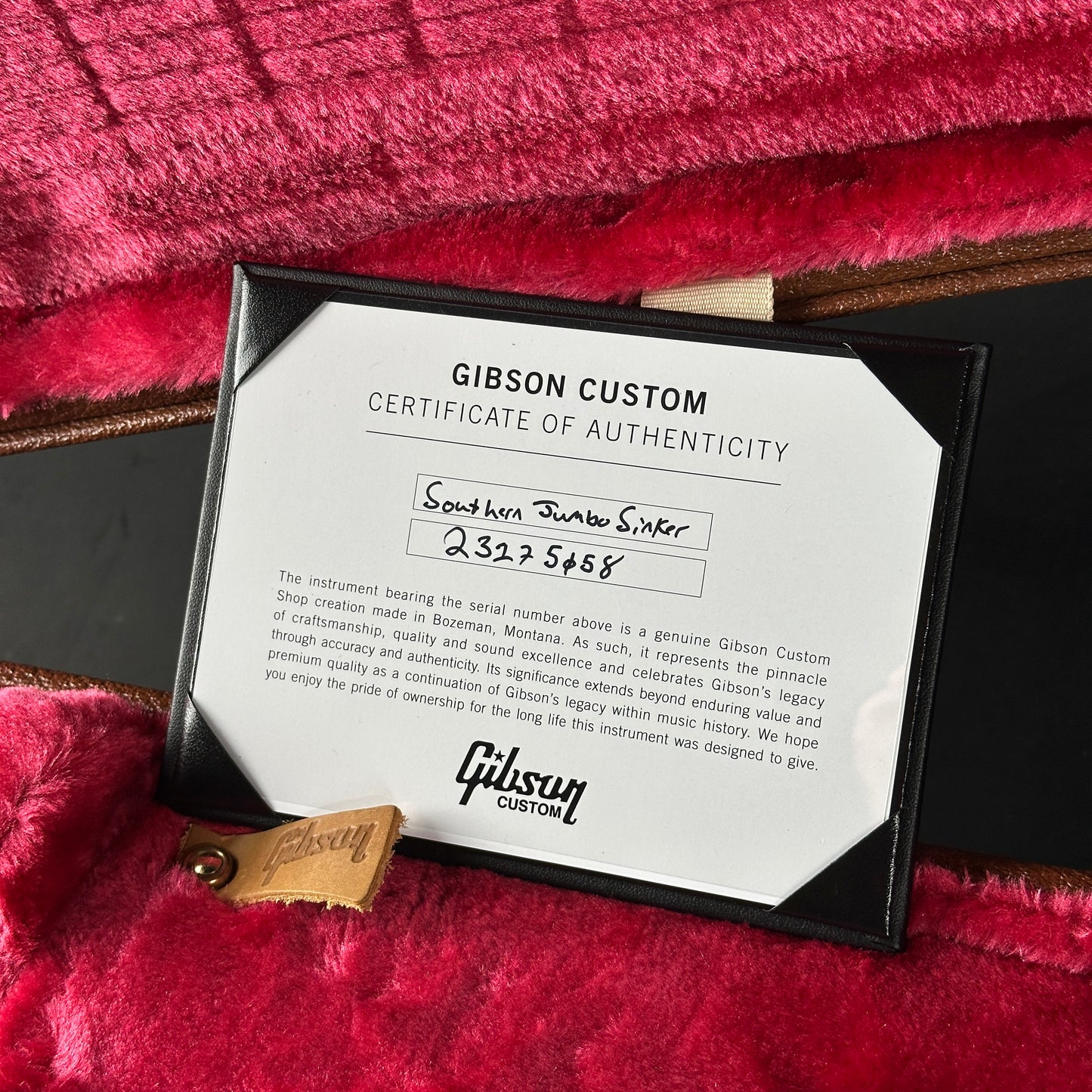 Gibson Custom Certificate of Authenticity on a red textured surface