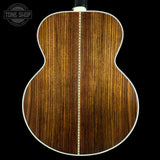 Close-up of a wooden acoustic guitar back with 'Tone Shop' logo.